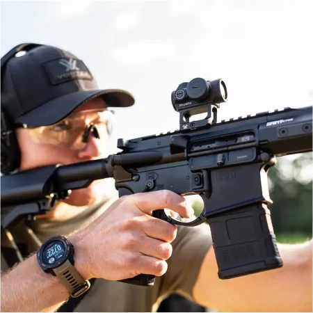 Kolimator karabinowy Vortex Triumph 2 MOA zamontowany na karabinku AR15 trzymanym w dłoniach przez strzelca.