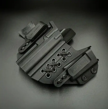 Kabura Glock 17 Doubletap Appendix Elastic IWB z ładownicą na ciemnym tle. Klipsy mocujące do pasa.