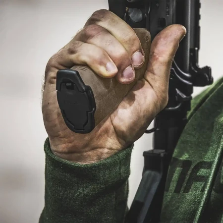 Chwyt pistoletowy Magpul MOE+ w kolorze FDE na karabinku AR-15 trzymanym przez strzelca.