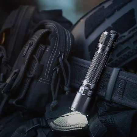 Latarka Fenix TK11R zamocowana na pasie.