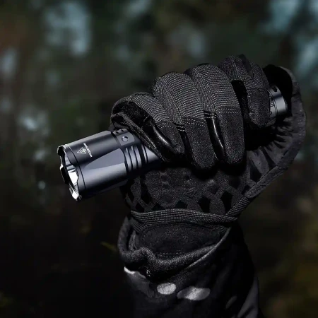 Fenix TK11R Latarka taktyczna LED trzymana w dłoni.