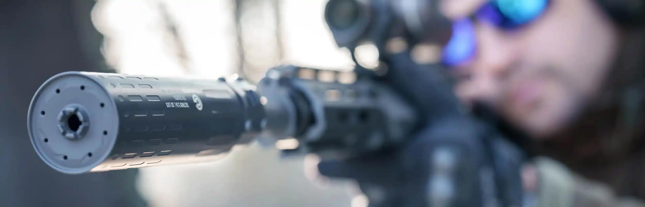 Gomander TACTINOX QD-LOCK L 5.56 mm - zbliżenie na tłumik zamontowany na lufie karabinka.