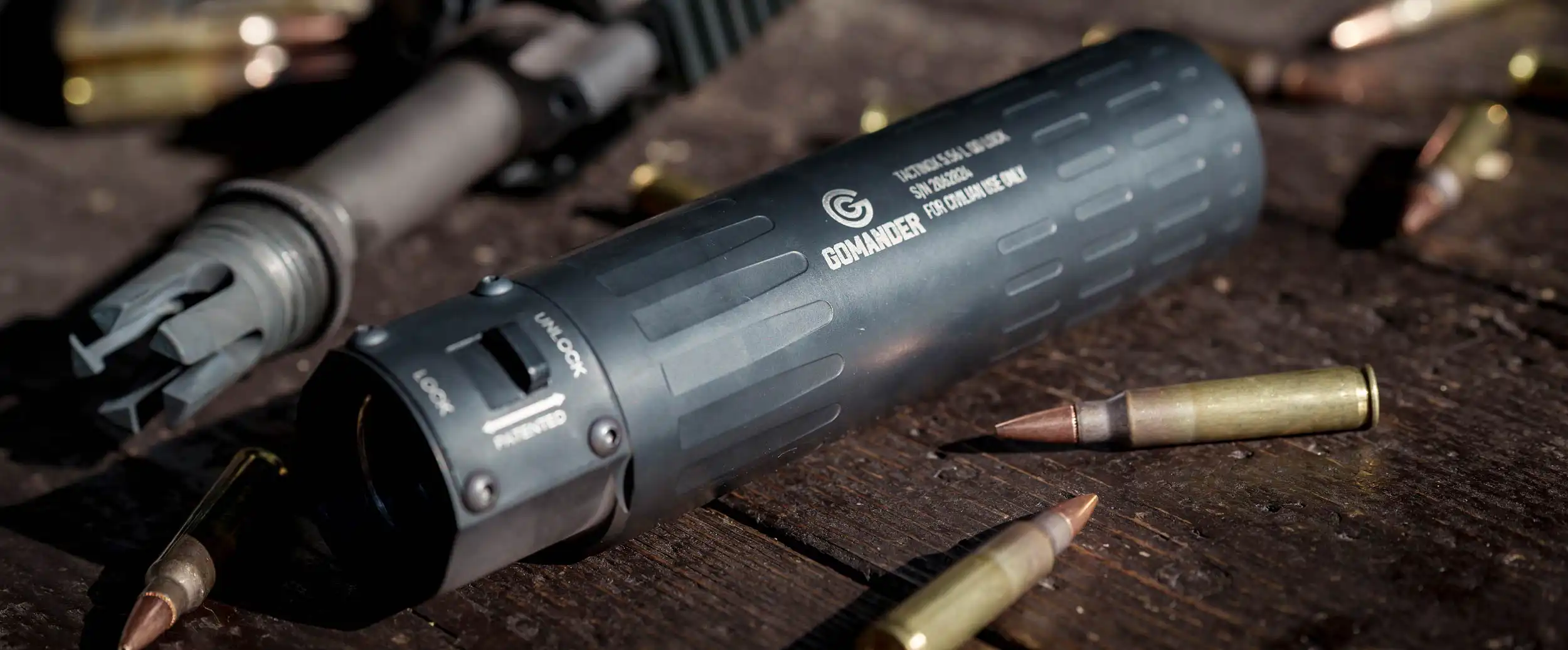 Gomander TACTINOX QD-LOCK L 5.56 mm na stole z karabinkiem i amunicją.