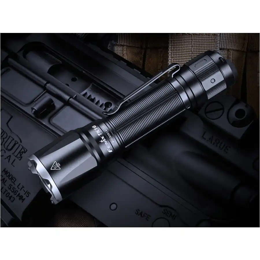Latarka taktyczna Fenix TK16 V2.0 leży na karabinku AR15.